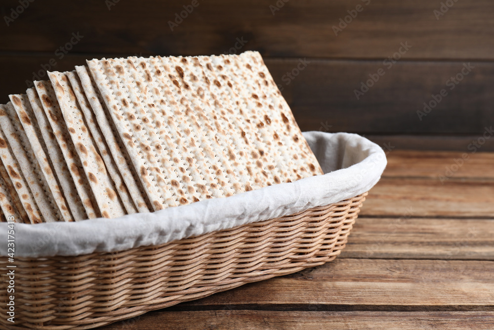 Traditional matzos in basket on wooden table