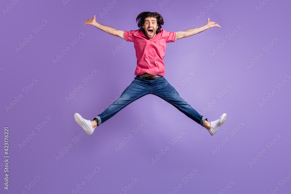 Full length photo of funny sportive young man wear pink t-shirt jumping like star isolated violet color background