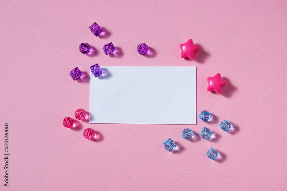 Background from pink colored sheet of paper and glass crystals. Top view, flat lay. Space for text on a white background.