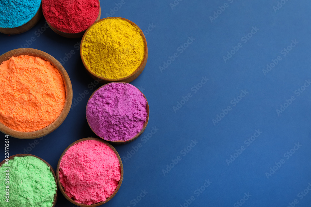 Colorful powders in bowls on blue background, flat lay with space for text. Holi festival celebration Colorful powders in bowls on blue background, flat lay with space for text. Holi festival celebration