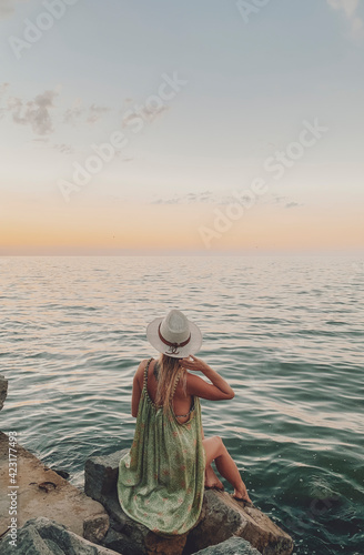woman staring at a sunset by the lake