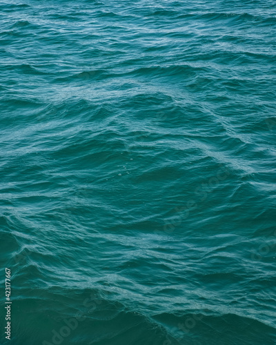 Beautiful sea water background. Cerulean color of the water. Marine surface, fresh and clean turquoise flow. Shiny blue ocean texture. © Derariad