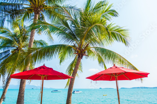 Red umbrella around sea beach ocean with coconut palm tree