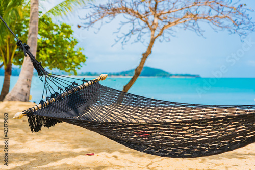 Empty hammock swing around beach sea ocean with white cloud blue sky © siraphol