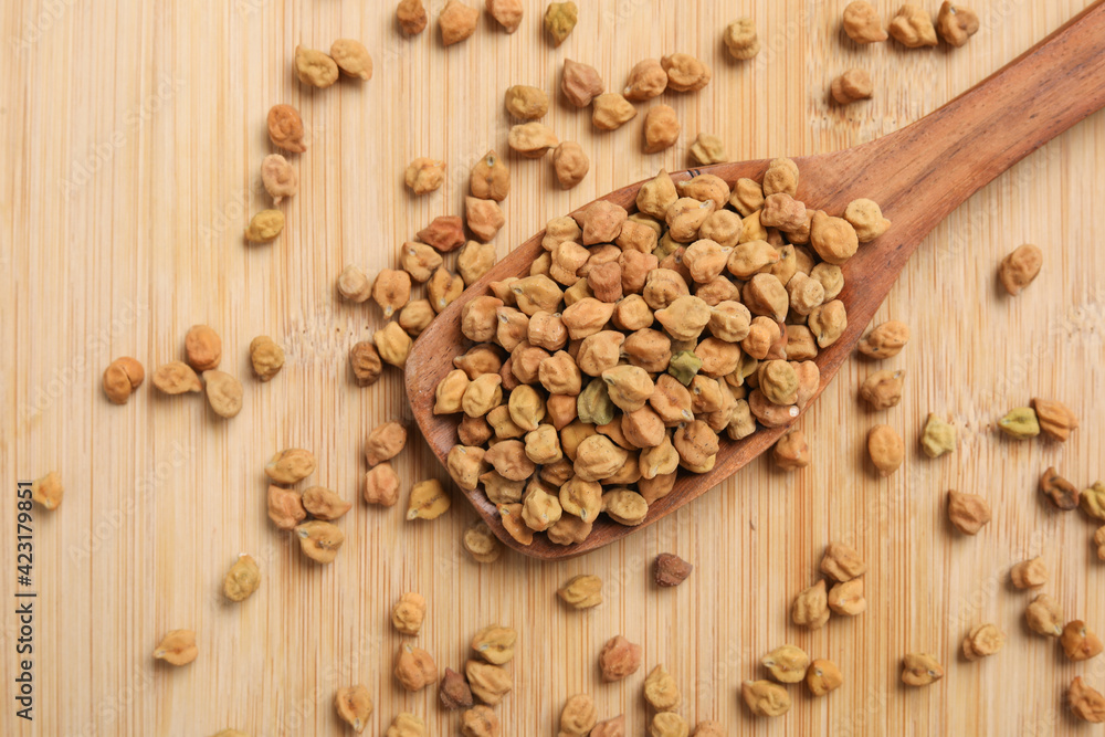 Dried chickpeas in wooden spoon on wooden background. Dried chickpeas in wooden spoon on wooden background.