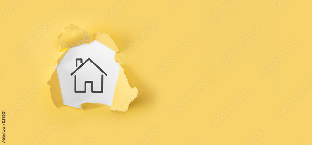 Real estate concept, businessman holding a house icon.House on Hand. Torn yellow paper with house on white background.Property insurance and security concept.