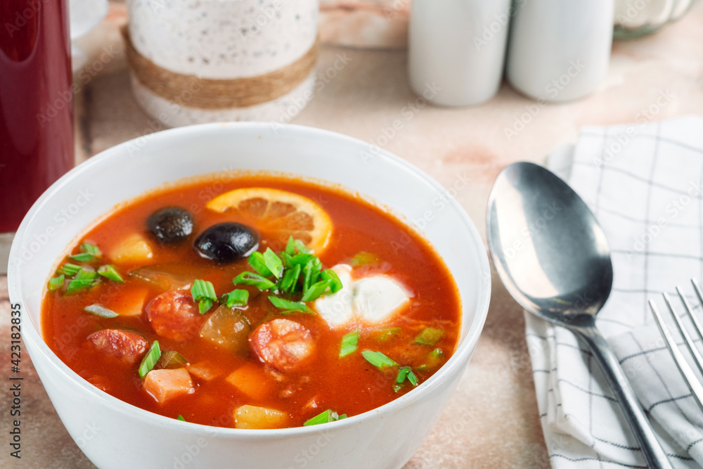 Russian soup Solyanka with smoked meat, sausages, vegetables, pickles and olives with lemon. Traditional Sour Soup Russian soup Solyanka with smoked meat, sausages, vegetables, pickles and olives with lemon. Traditional Sour Soup