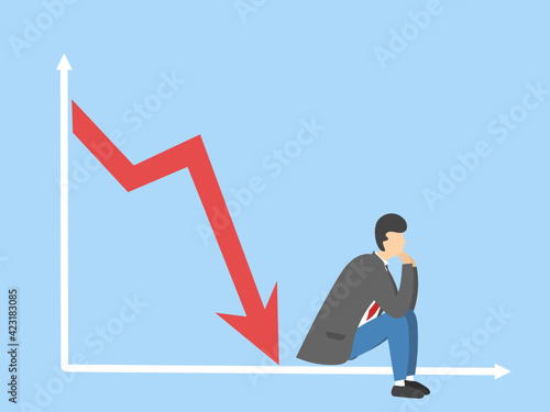 The graph illustrating the stagnation and decline of indicators and a sad businessman is sitting in thought. Bankrupt.