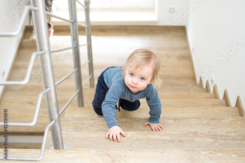 Wallpaper Mural Small caucasian baby crawling on the stairs. Indoor portrait with copy space. Kid danger and safeness at home. Torontodigital.ca