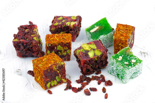 Turkish delight pomegranate with pistachios, covered with barberry berries. Apple Turkish delight. Turkish sweets on a white background.