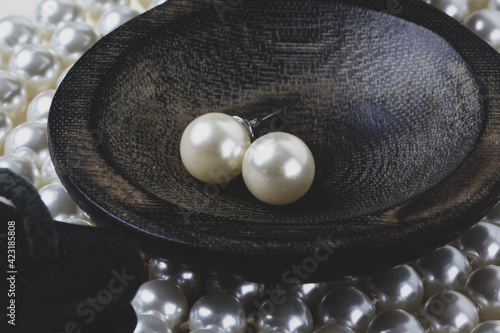 pearl necklace and pearl earrings in a bowl