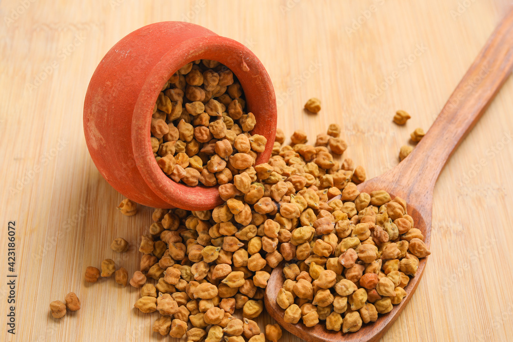 Dried chickpeas in bowl isolated on wooden background.
