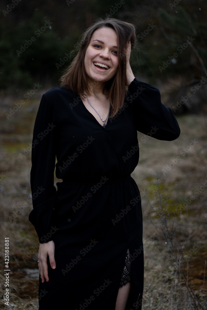 young brunette woman with short hair in a black dress on the nature young brunette woman with short hair in a black dress on the nature