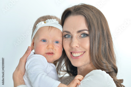 close up portrait of young mother hugging her cute little daughter