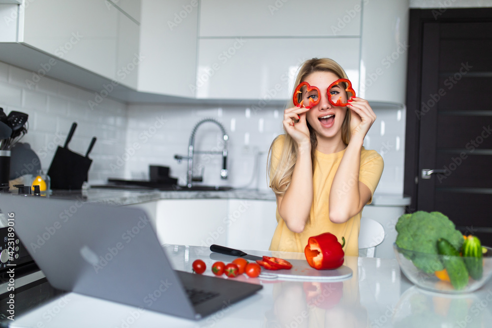 Young housewife playing with food cut slices of sweet paper while cooking in the kitchen. Healthy food at home. Healthy food leaving - vegan concept. Young housewife playing with food cut slices of sweet paper while cooking in the kitchen. Healthy food at home. Healthy food leaving - vegan concept.
