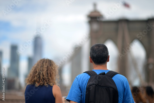 back view of pedestrians looking at Brooklyn bridge, NYC, USA