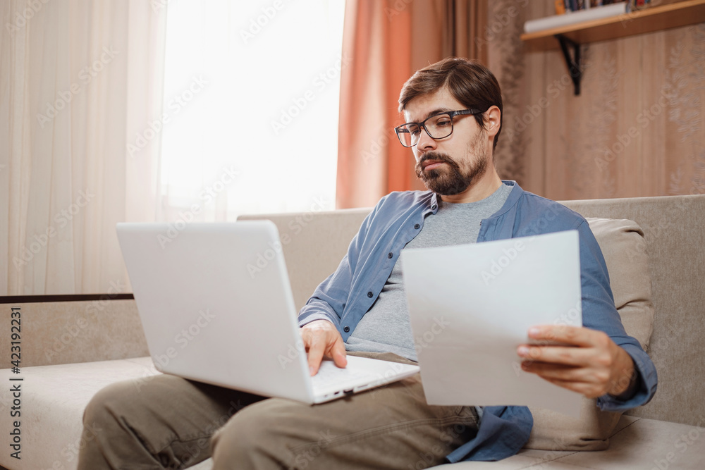 Entrepreneur works with a laptop and keeps a document in a home office Entrepreneur works with a laptop and keeps a document in a home office