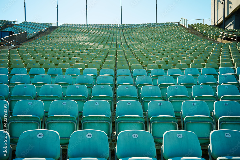 Fototapeta premium leeres Stadion im Freien bei sonnigem Wetter grüne Plastikstühle