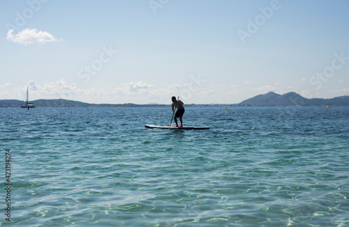 
Hombre haciendo paddle surf  de vacaciones en el mar mediterraneo