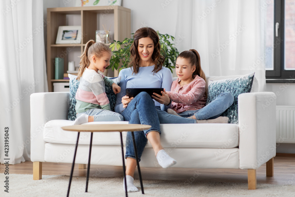 people, family and technology concept - happy mother and two daughters with tablet pc computer at home people, family and technology concept - happy mother and two daughters with tablet pc computer at home