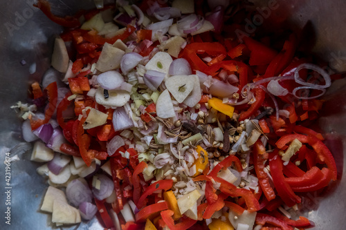 Colorful mix of different chopped spices in metal bowl