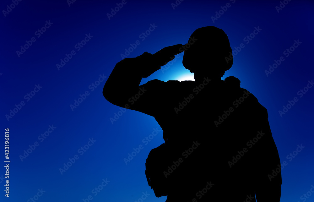 Silhouette of soldier in combat helmet and ammunition saluting on ...