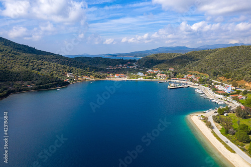 Panoramic top view on Mediterranean sea blue water with white sandy beach road along green hills coastline, yachts and boats pier, tourist hotels, summer vacation villas