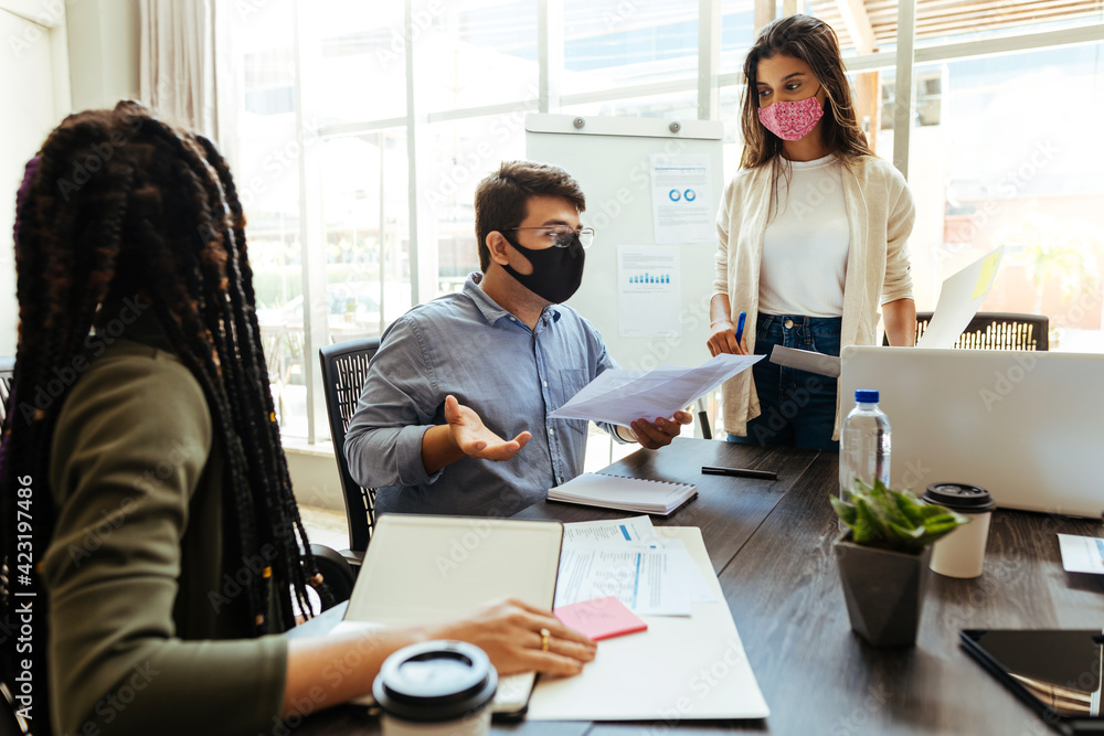 Business team wearing protective masks while meeting in the office during the COVID-19 epidemic Business team wearing protective masks while meeting in the office during the COVID-19 epidemic