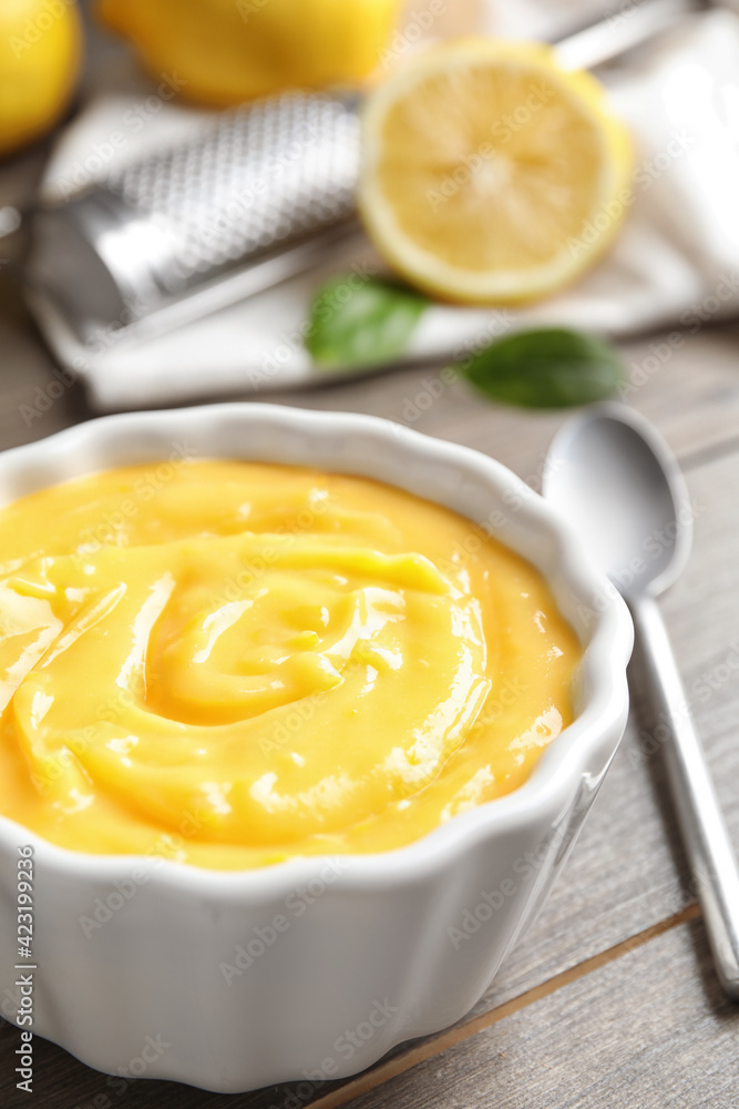 Delicious lemon curd in bowl on wooden table, closeup Delicious lemon curd in bowl on wooden table, closeup