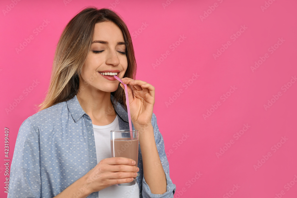 Young woman drinking chocolate milk on pink background. Space for text Young woman drinking chocolate milk on pink background. Space for text