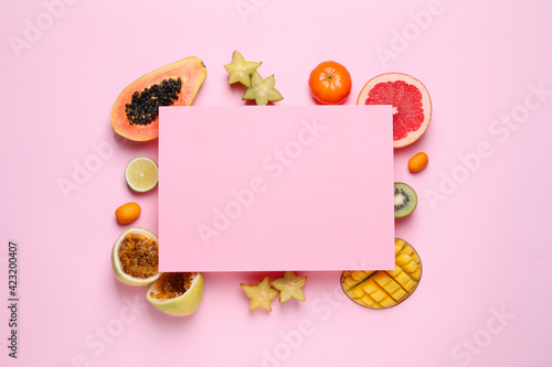 Different exotic fruits and blank card on pink background, flat lay. Space for text