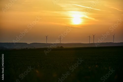 Windräder im Sonnenuntergang mit Abendrot am Himmel bei Schweinfurt, Franken, Bayern, Deutschland 