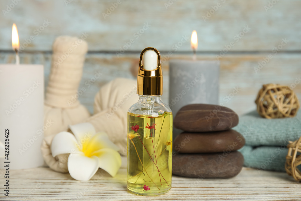 Bottle with essential oil on white wooden table. Spa product Bottle with essential oil on white wooden table. Spa product