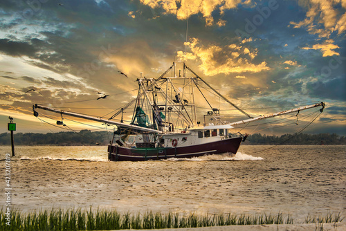 A shrimp boat entering Charleston, SC harbor in the evening.