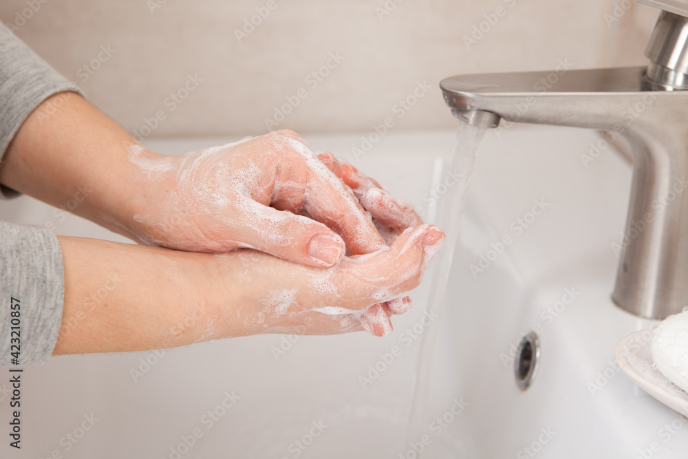 Proper hand washing as a prevention of coronavirus. Close-up of women's hands in soap in the bathroom Proper hand washing as a prevention of coronavirus. Close-up of women's hands in soap in the bathroom