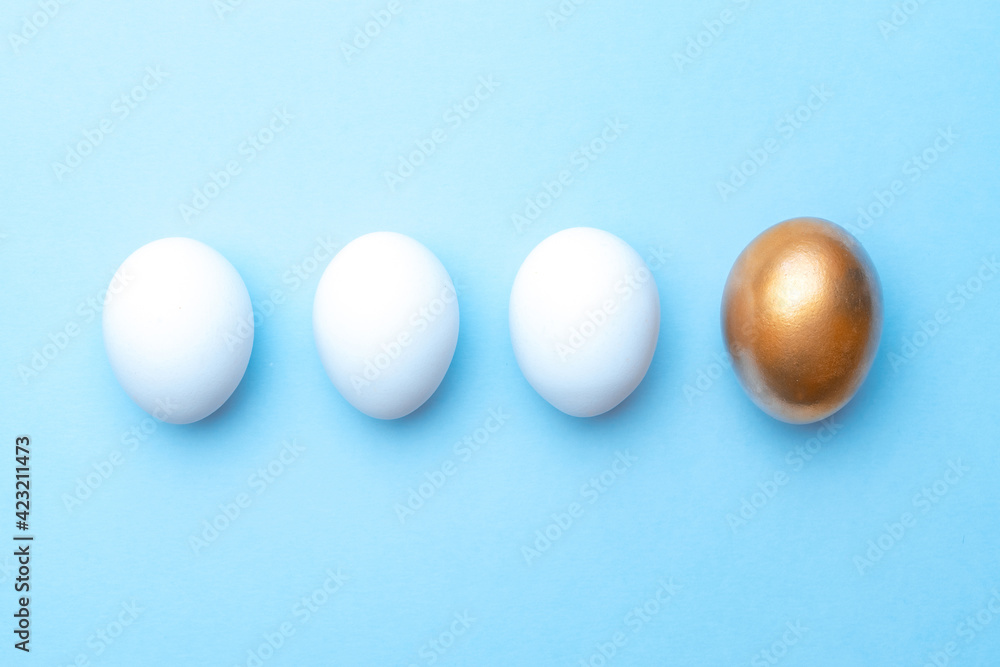 Easter background blue. Golden, white colour egg on pastel blue background in Happy Easter decoration. Flat lay, top view. Easter background blue. Golden, white colour egg on pastel blue background in Happy Easter decoration. Flat lay, top view.