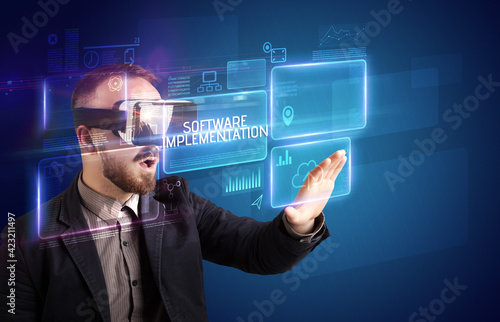 Businessman looking through Virtual Reality glasses, tech concept