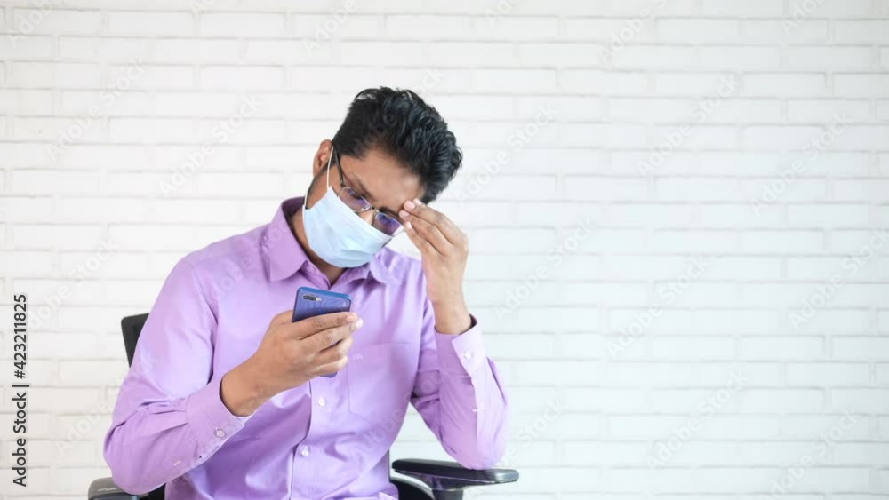 sick young man in surgical face mask using smart phone sick young man in surgical face mask using smart phone
