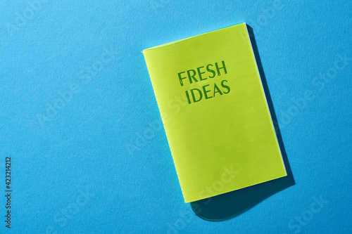 Directly Above Shot Of Note Pad with text fresh ideas On blue Background