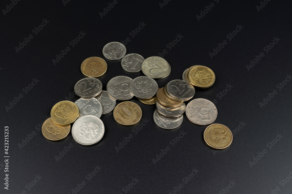 small metal coin heap on black background small metal coin heap on black background
