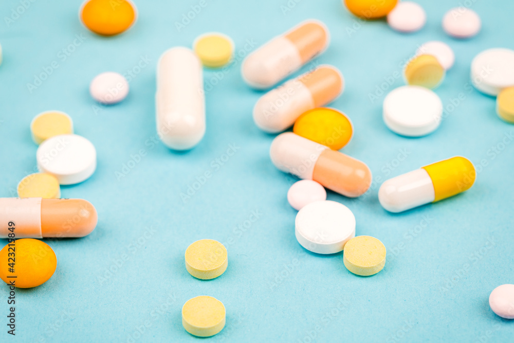 A bunch of pills on a blue background. The concept of healthcare A bunch of pills on a blue background. The concept of healthcare