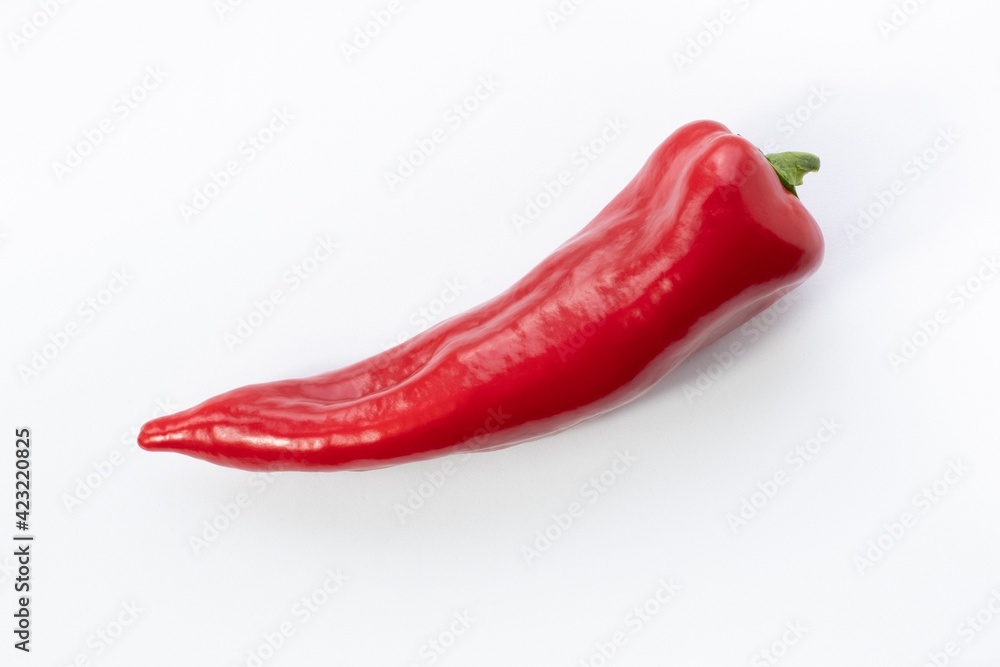 A beautiful red bell pepper lies horizontally on a white background. Minimalism, isolated.