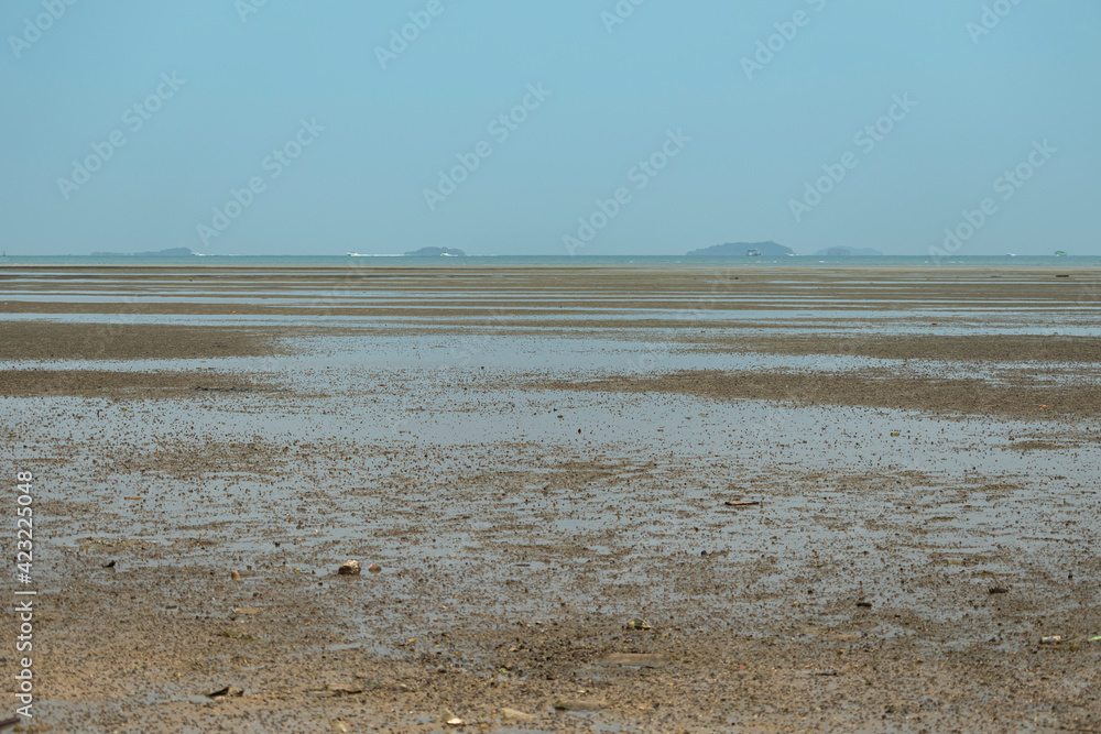 Sand floor on the beach after the sea has dropped. Become a wide beach with a background of a passenger ship