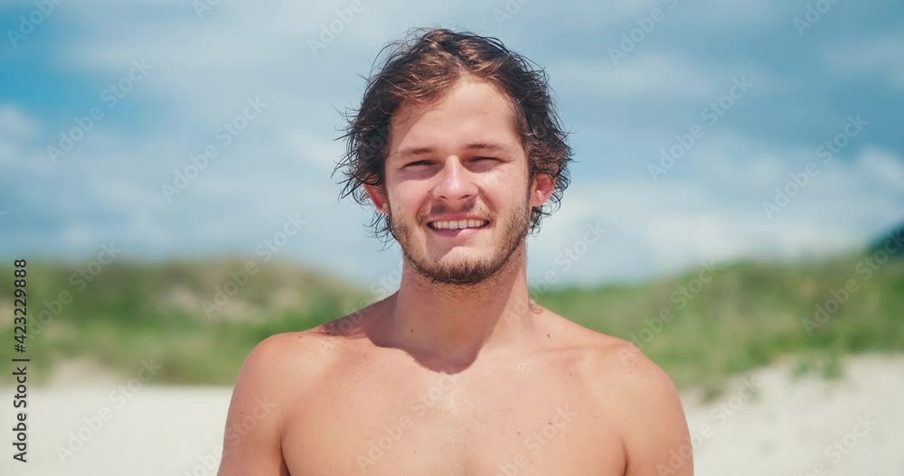 Young man's portrait. Portrait of the young Brazilian surfer on the beach. Hand held camera Young man's portrait. Portrait of the young Brazilian surfer on the beach. Hand held camera