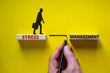 Stress management symbol. Wooden blocks with words 'Stress management'. Yellow background. Businessman hand, businessman icon. Psychological, business and stress management concept. Copy space.
