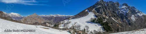 Extra wide view of the Mount Resegone and the Grigna witn snow and blue sky