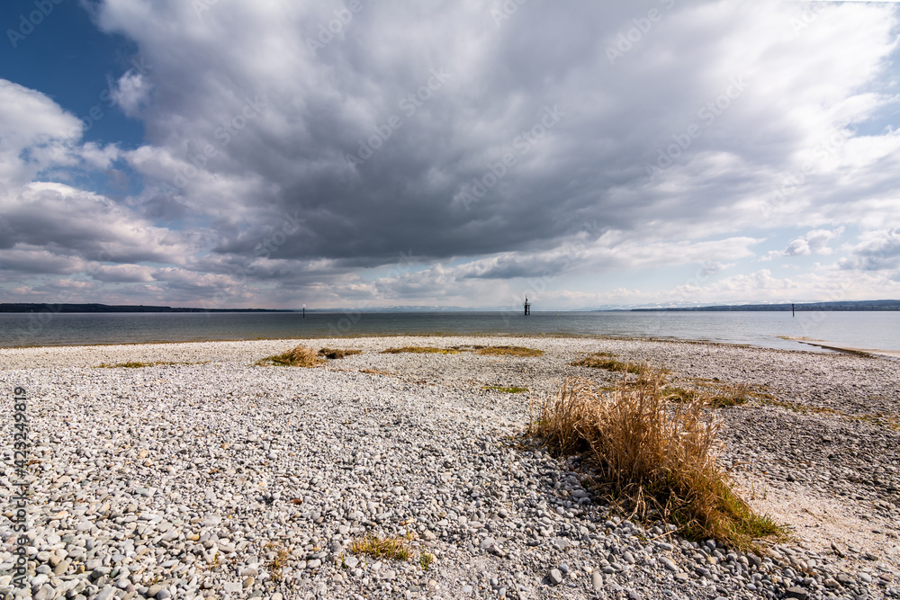 Beach, grass and clouds over Lake Constance in Germany