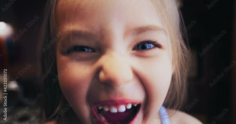 The image goes into defocus. The girl is a child with thick long hair, turns, looks at the camera and smiles. Selective focus. The video is out of focus. The concept of a happy life. The image goes into defocus. The girl is a child with thick long hair, turns, looks at the camera and smiles. Selective focus. The video is out of focus. The concept of a happy life.
