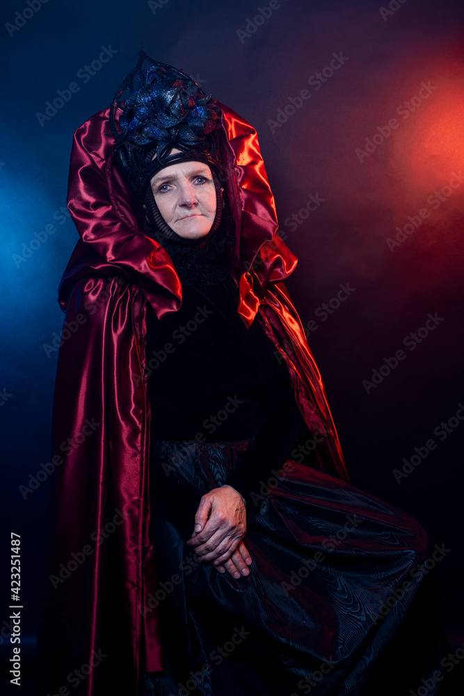 Fabulous creature, historical character, fantasy queen, witch, in costume. Woman, model after 60, in the studio, dark background Fabulous creature, historical character, fantasy queen, witch, in costume. Woman, model after 60, in the studio, dark background