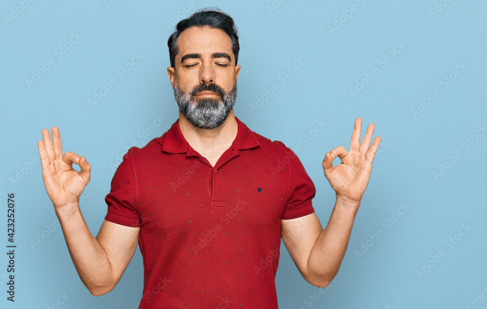 Middle aged man with beard wearing casual red t shirt relax and smiling with eyes closed doing meditation gesture with fingers. yoga concept. Middle aged man with beard wearing casual red t shirt relax and smiling with eyes closed doing meditation gesture with fingers. yoga concept.
